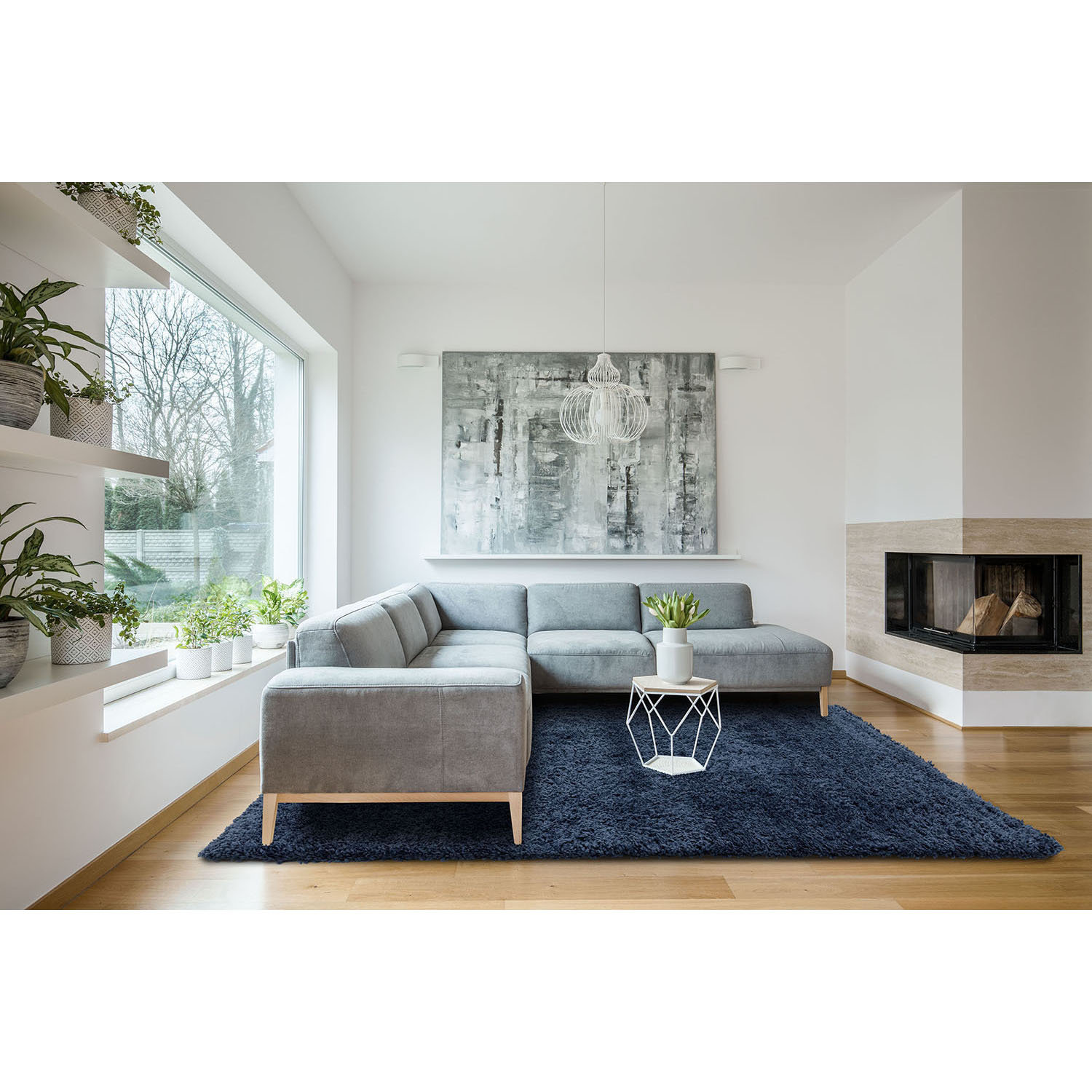 Spacious white living room interior with grey corner couch, big